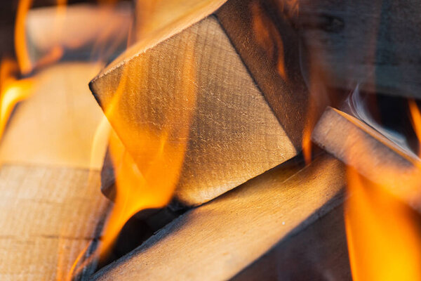 lighting a fire, flame, a warm fireplace with lots of trees ready for barbecue, burning firewood, wood. Selective focus. Close view. The concept of fire, burning