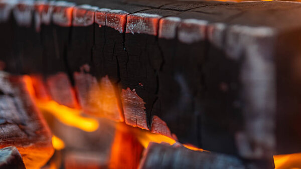 Close view. The concept of fire, burning. Lighting a fire, flame, a warm fireplace with lots of trees ready for barbecue, burning firewood, firewood. Selective focus.