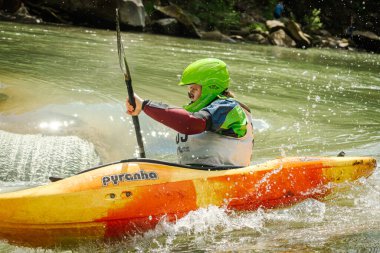 Yaremche şehri, Ivano-Frankivsk bölgesi, Ukrayna, 5 Haziran 2021. Yazın dağlarda tehlikeli ve huzursuz bir nehirde renkli bir kanoya atlamak. Dalgalar, aktif dinlenme, yüzme