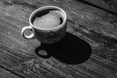 Beyaz fincanda bir fincan kahve ve gri tarçınlı ahşap bir yüzey üzerinde bir çay kaşığı çay, açık renk, sabah kahvesi, üst manzara.