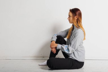 Beyaz arka planda izole edilmiş kopyalama alanına bakan düşünceli, genç ve duygusal bir kızın portresi. Uzay konsepti ve güzel kız