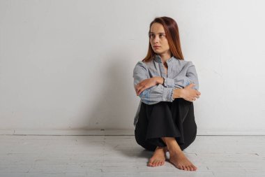 Beyaz arka planda izole edilmiş kopyalama alanına bakan düşünceli, genç ve duygusal bir kızın portresi. Uzay konsepti ve güzel kız