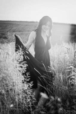 Gün batımı, yumuşak akşam renkleri, altın buğday tarlasında uzun saçlı, genç, güzel, duygusal esmer bir kız. Huzur, huzur, neşe, doğa 