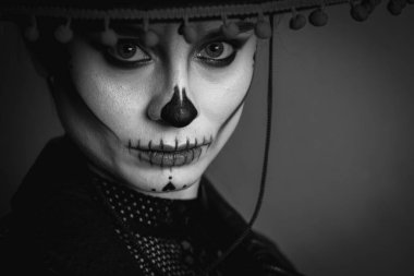 Calavera Katrina 'nın yakın plan portresi. Kafatası makyajı gri arka planda bir şapkada düz, ciddi bir görünüş. Dia-de -los -muertos. Ölüm günü. Cadılar Bayramı