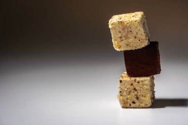 Beyaz ve çikolata parçalı kurabiyeler üst üste dizilmiş, piramit gibi, açık arkaplanda. Güzel kavram.