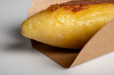 Lezzetli mantar sosuyla servis edilen paket servis kutusunda altın sarısı patates köftesi. Geleneksel yemekler, konfor yemekleri ve yemek konseptleri için mükemmel.