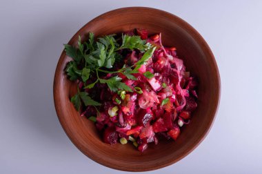 Geleneksel Vinaigrette pancar salatası, sebzeli ve maydanozlu beyaz arka planda kırsal seramik kasede. Sağlıklı vejetaryen aperatifler, organik yiyecekler.