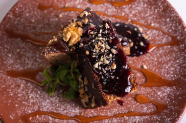 Çikolata jöleli ve kil tabakta naneli fındıklı kek dilimi. Ev yapımı ballı tatlı, ceviz ve karamel şurubu. Gurme tatlı pasta konsepti