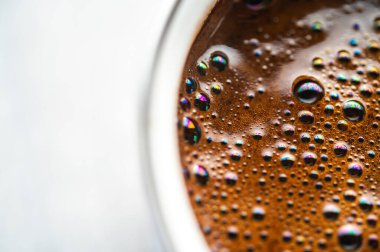 Yanardöner gökkuşağı yansımalı krema köpüklerinin makro arkaplanı. Soyut sıvı espresso yüzeyi. Sanatsal kafein konsepti, aşırı yakın çekim.