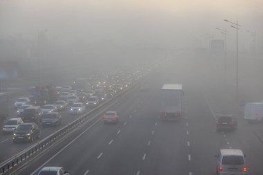 Sabah sisli havada şehir caddesinde hareket eden arabalar.