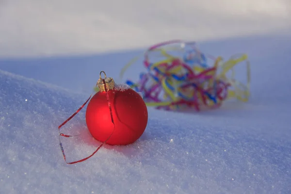 白い雪の上のクリスマスツリーのおもちゃの赤いボール — ストック写真