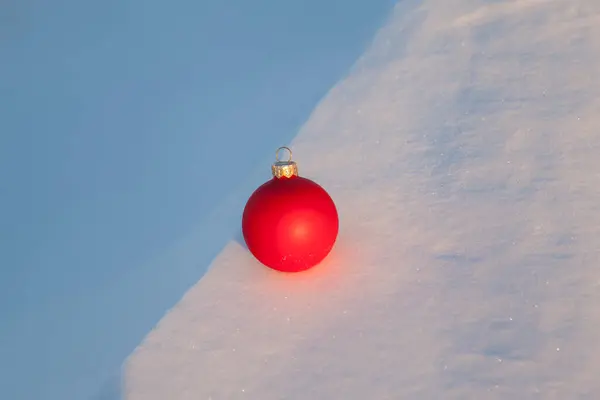 白い雪の上のクリスマスツリーのおもちゃの赤いボール — ストック写真