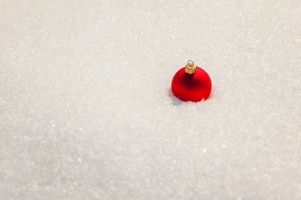 白い雪の上のクリスマスツリーのおもちゃの赤いボール — ストック写真