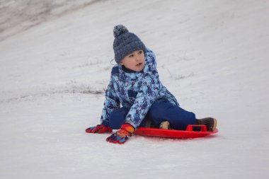 Kışın giydiği beyaz kar tabaklı küçük çocuk.