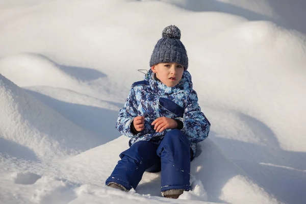 雪の中に座っている少年は — ストック写真