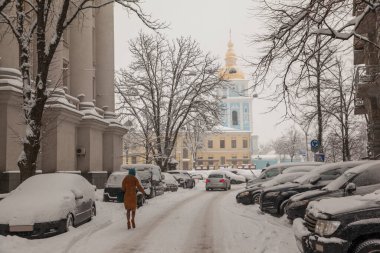 Karla kaplı evleri, ağaçları, arabaları olan kış şehirleri. Şehirde yoğun kar yağışı var. St. Michael 's Altın Kubbe Katedrali. Kiev. Ukrayna.
