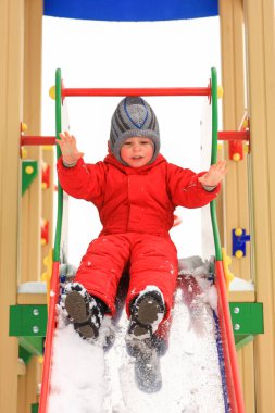 Kış giysileri içinde çocuk tepesinden gelen küçük bir çocuk.