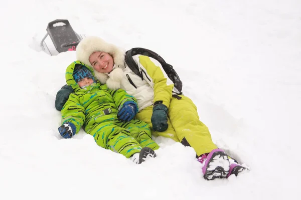 Ευτυχισμένη Μαμά Γιο Της Ξαπλωμένο Στο Χιόνι Ενώ Κάνει Έλκηθρο — Φωτογραφία Αρχείου
