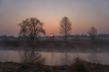Bahar manzarası. Bahar nehrinin üzerinde şafak.