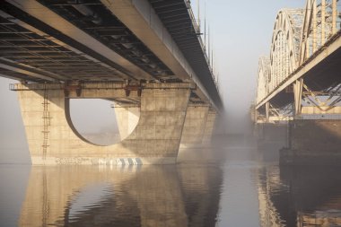 Büyük bir nehrin üzerinde bir köprü ilkbaharın başlarında nehirde sis.