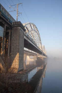 Büyük bir nehrin üzerinde bir köprü ilkbaharın başlarında nehirde sis.