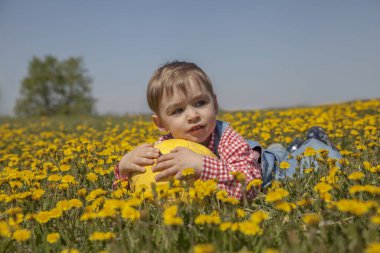 Bir çocuk futbol topuyla bir sahanın ortasında yatıyor.