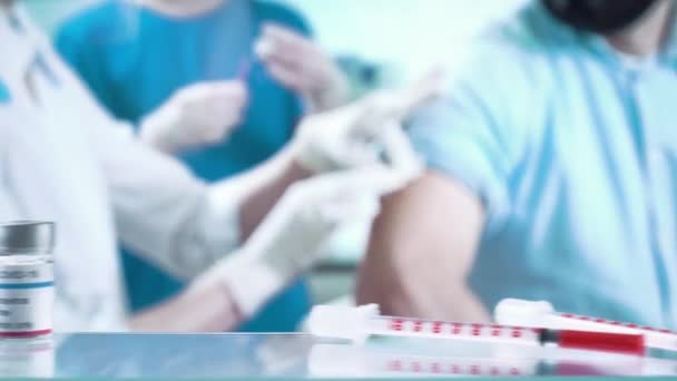 Un'infermiera sta iniettando un vaccino ad un paziente della clinica. — Video Stock