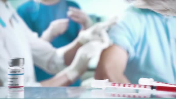 Μια νοσοκόμα κάνει ένεση εμβολίου σε έναν ασθενή στην κλινική.. — Αρχείο Βίντεο