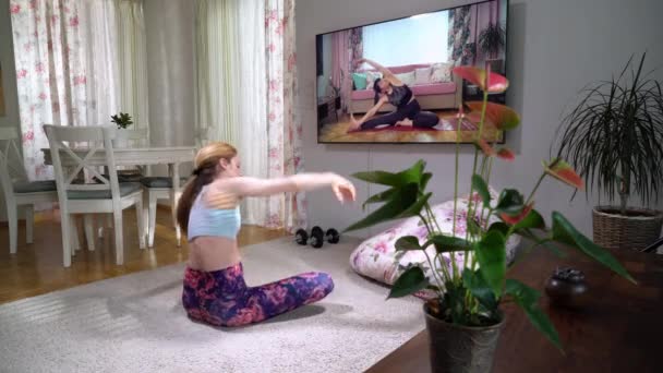 Oturma odasında yoga videosunu izleyen bir kadın. — Stok video