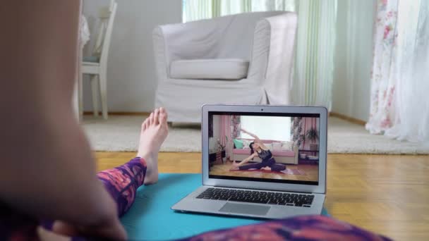 거실에서 요가 온라인 동영상 강의를 듣고 있는 여성 — 비디오