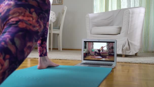 Женщина после йоги онлайн видео учебник в своей гостиной — стоковое видео