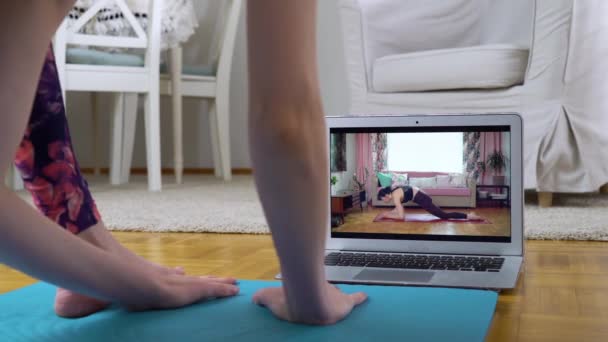 Nő követően jóga online video tutorial a nappalijában — Stock videók