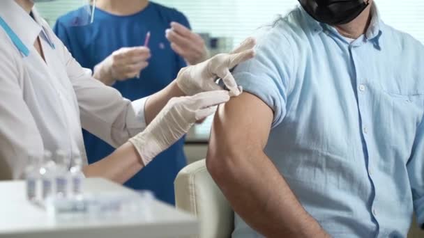 O médico dá a vacina para o paciente na clínica. — Vídeo de Stock