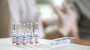 Bir hemşire klinikteki bir hastaya aşı enjekte ediyor..