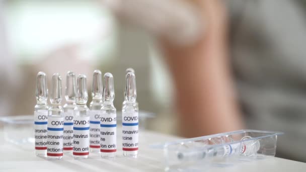 看護師がクリニックで患者にワクチンを注射しています. — ストック動画
