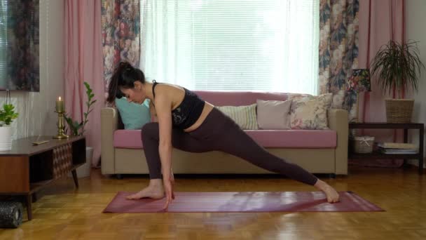 Fit tânără femeie care practică yoga la domiciliu — Videoclip de stoc