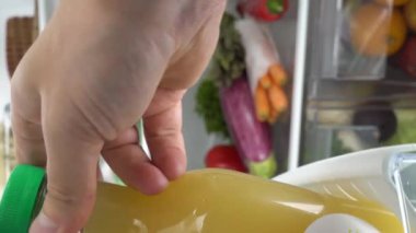 Kadın buzdolabının kapısını açıyor. İçi yemek dolu. Farklı yiyecekler.