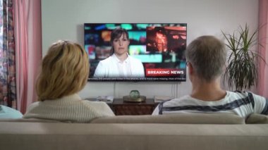 Aile Çifti TV Haberleri İzliyor Oturma odasında Kanepede Oturuyor