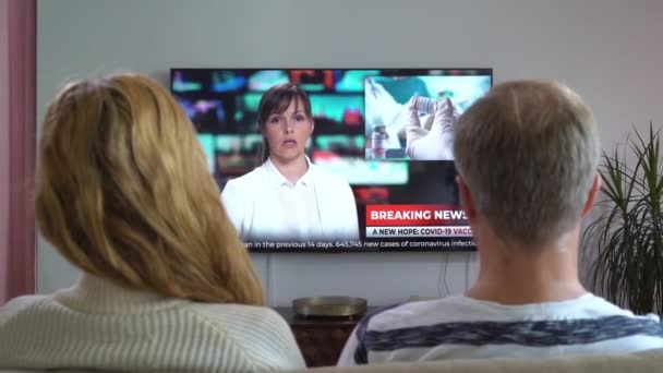 Familie paar Kijken TV Nieuws Zittend op de bank in de woonkamer samen. — Stockvideo