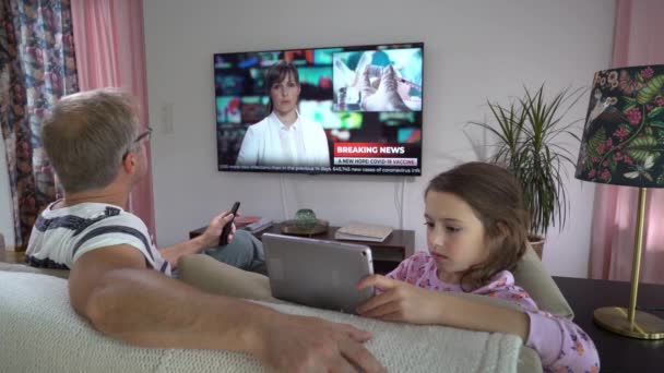 함께 거실에 앉아 텔레비전 뉴스를 시청하는 가족. — 비디오
