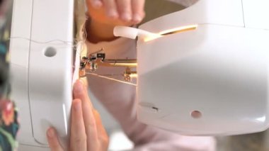 Anne evde kreşte bir dikiş makinesi kullanarak dikiş küçük kızı öğretiyor