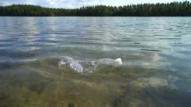 Doğadaki plastik çöpler. Suda yüzen kullanılmış şişe..