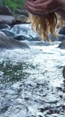 Yazın temiz bir ormandan tatlı su içen genç bir kadın. Saf doğa, huzur ve ferahlık. Vahşi doğada sakin bir an, doğa ve doğal yaşam arasındaki bağın sembolü..