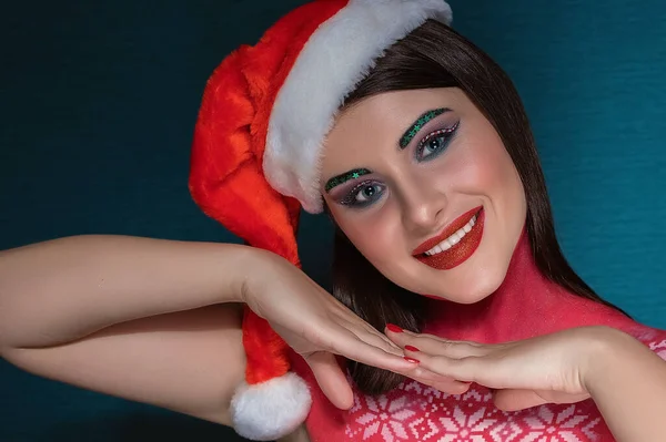 Hermosa mujer morena con maquillaje de arte creativo con sombrero de Santa Claus sonriendo a la cámara —  Fotos de Stock