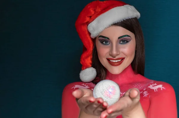 Krásná brunetka žena s kreativním uměleckým make-up na sobě Santa Claus klobouk s úsměvem na kameru — Stock fotografie