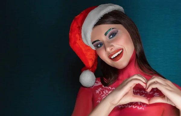 Bella donna bruna con trucco artistico creativo che indossa il cappello di Babbo Natale sorridente alla fotocamera — Foto Stock