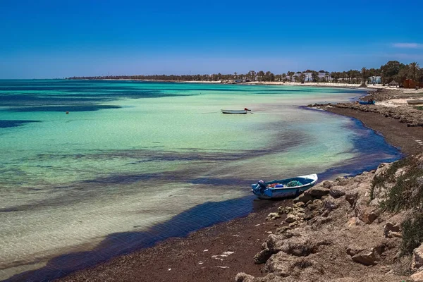 Maravillosas vistas de la costa mediterránea con agua de abedul, playa de arena blanca y un barco pesquero — Foto de Stock