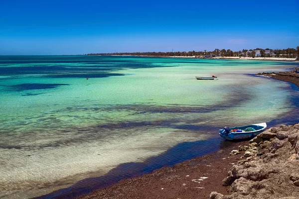 Maravillosas vistas de la costa mediterránea con agua de abedul, playa de arena blanca y un barco pesquero — Foto de Stock