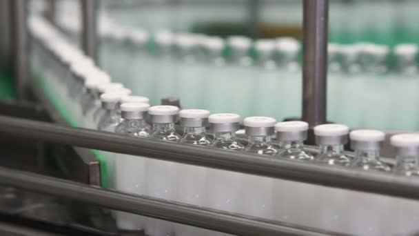 Lahvičky s léky na řádku dopravník v farmaceutické továrně — Stock video