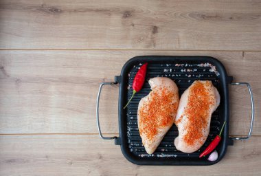 Çiğ tavuk göğsü, baharat ve kırmızı biber. Tavuk fileto ızgarada. Üst Manzara. Boşluğu kopyala.